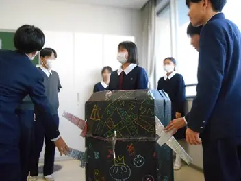 手作りの樽と剣でゲームをしている生徒達