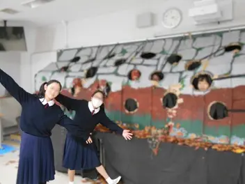 人間もぐらたたきの前で手を伸ばす女子生徒達