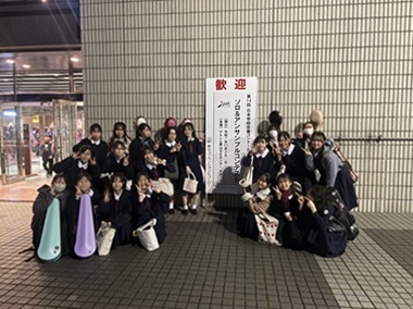 コンテストの看板の前での生徒の集合写真