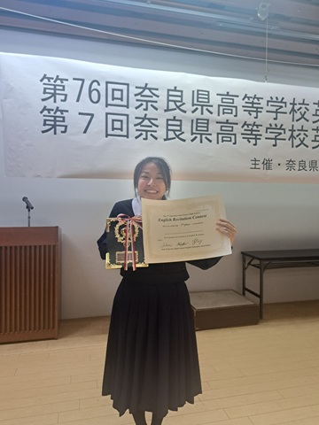 表彰盾と賞状を持って笑顔の高校生徒