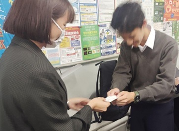 会釈しながら講演者から名刺を受け取る男子生徒
