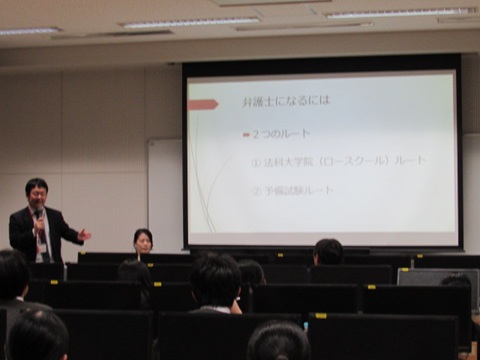 マイクで講演されている弁護士の城之内太志先生