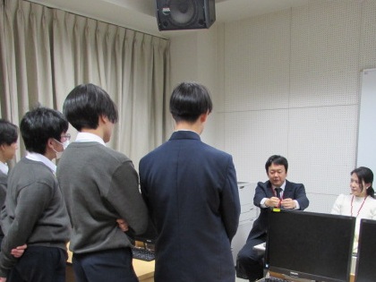 弁護士の先生の説明を聞く男子生徒4名