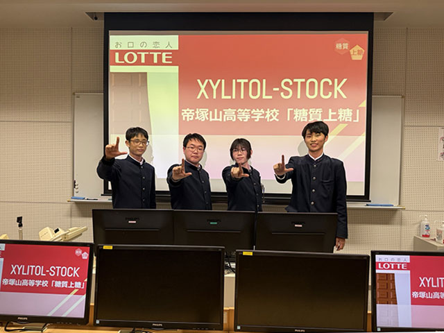 左手でLのポーズ姿の男子高校生4人