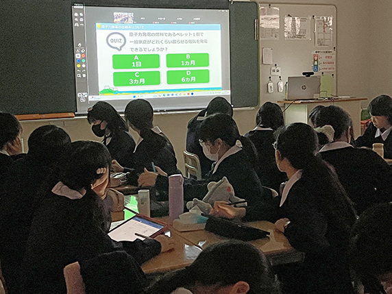 黒板に表示されるスライドと女子生徒達