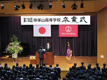 大勢の生徒達の前で卒業証書を受け取った１人の男子生徒