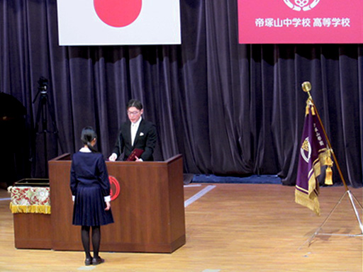 女子生徒が校長から卒業証書授与されている様子