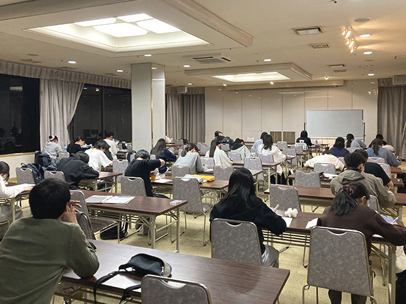 会議室みたいな部屋で机に向かって勉強する生徒達