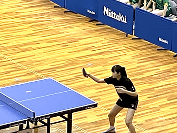 中学女子１人が卓球のボールを受けようとしているところ