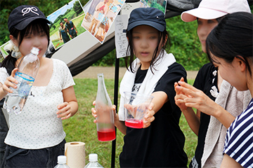 赤シソジュースを注ぐ人、ソーダを割る人等分担する女子生徒4人