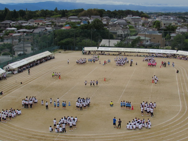 複数人で1本の長い棒を持ち走っている台風の目という競技風景