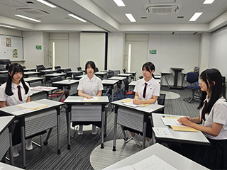 留学する高1女子4名が教室で椅子に座って話を聞いている様子