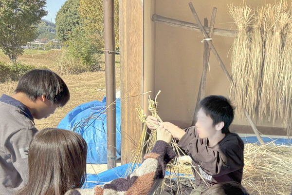 男子生徒と女子生徒が協力してしめ縄作りしている様子