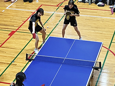 相手のサーブを待つ女子ダブルスの試合