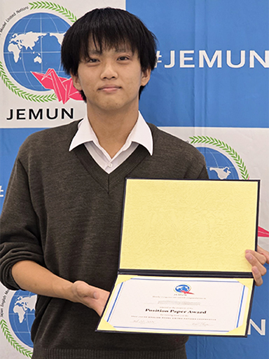 高校2年男子がPosition Paper Awardの賞状を持って記念撮影