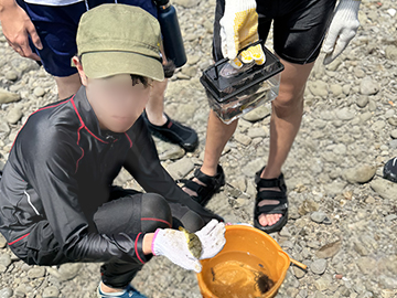 女子生徒が手のひらに魚を置いて見せている