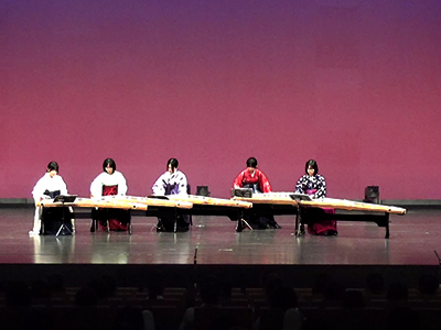 白や赤、紫の袴姿で演奏する5人の琴部員